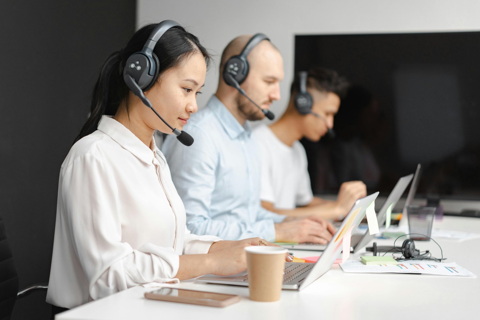 Atendente de suporte técnico sorrindo e falando com cliente pelo headset